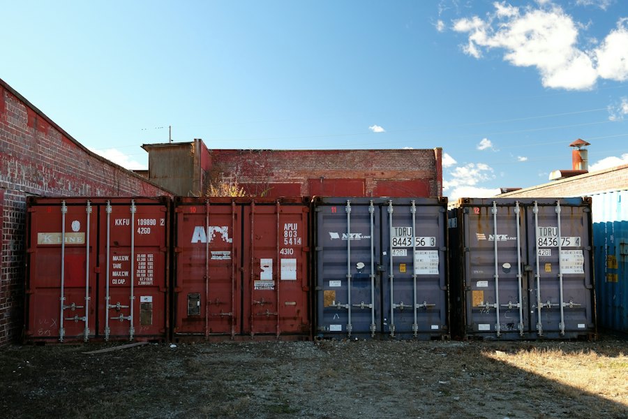 Row of shipping containers behind commercial buildings